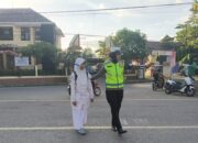 Bantu Siswa Menyeberang, Polisi Ingatkan Pengendara Gunakan Helm SNI dan Lengkapi Surat Kendaraan